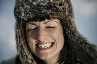 Mittlere erwachsene Frau mit Jägermütze, lächelnd mit geschlossenen Augen - MJRF00505