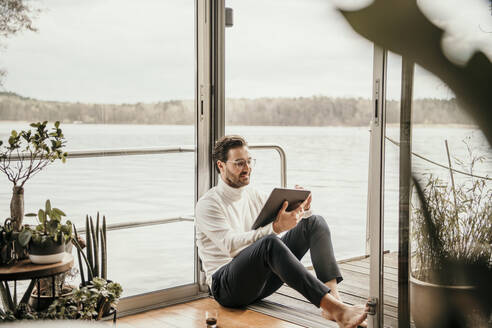 Männlicher Freiberufler mit digitalem Tablet auf einem Hausboot - MJRF00509