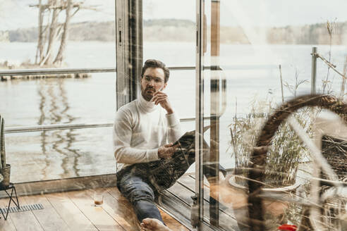 Thoughtful male professional working on houseboat - MJRF00518