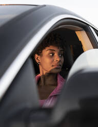 Nachdenkliche Frau, die vom Fenster im Auto wegschaut - JCCMF02538