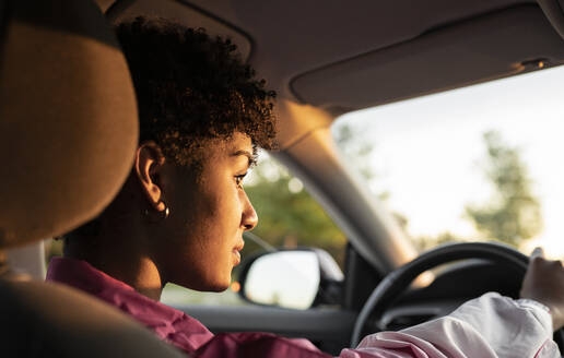 Junge Frau fährt Auto an einem sonnigen Tag - JCCMF02540