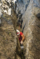 Mann klettert auf Felsen - JMPF00956