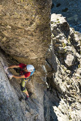 Male climber moving up on rocky mountain - JMPF00958