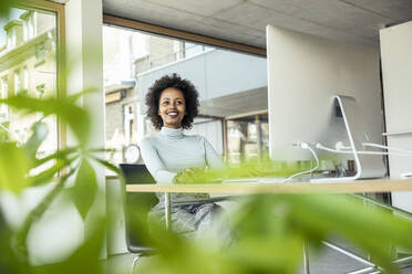 Afroamerikanische Frau, die in einem professionellen Büro an einem Computer arbeitet - UUF23248