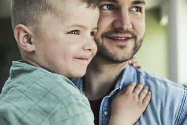 Smiling cute boy with father looking away - UUF23350