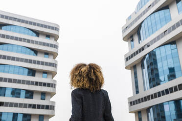 Afro-Geschäftsfrau steht vor einem Bürogebäude in der Stadt - JRVF00628