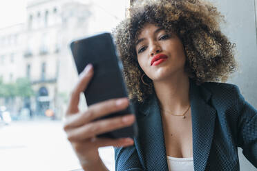 Schöne Geschäftsfrau Textnachrichten über Smartphone in einem Café - JRVF00648