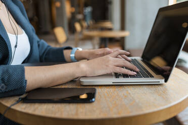 Female freelance worker using laptop in cafe - JRVF00651