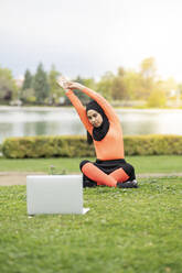 Arab woman learning exercises on laptop in park - JCCMF02589