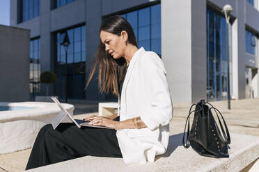 Reife Geschäftsfrau mit digitalem Tablet an einem sonnigen Tag - JRVF00659