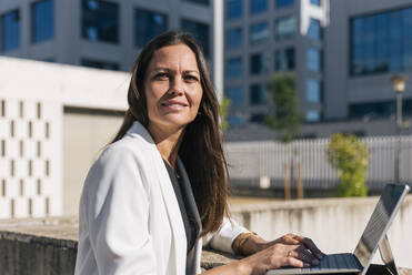 Smiling businesswoman with digital tablet on sunny day - JRVF00676