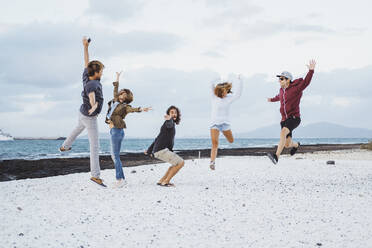 Carefree friends jumping at beach - DGOF02217