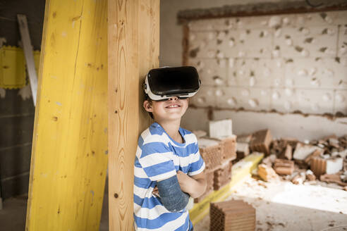 Boy with broken arm using virtual reality headset at loft apartment - HMEF01248