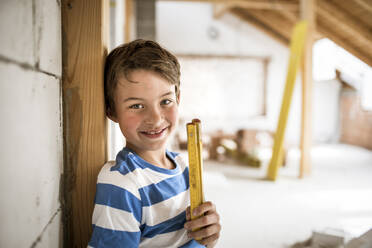 Junge mit Zollstock bei der Renovierung des Dachbodens - HMEF01251
