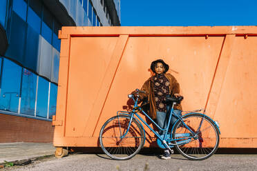 Junge Frau mit Fahrrad auf einem Fußweg an einem sonnigen Tag - MEUF02981