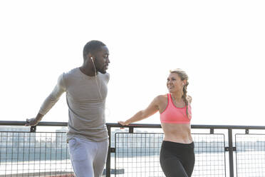 Smiling woman looking at man while exercising together - WPEF04578