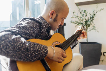 Man playing guitar at home - MEUF03016