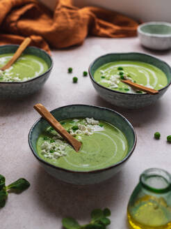 Von oben köstliche Erbsencremesuppe in Schalen auf dem Tisch serviert - ADSF24604