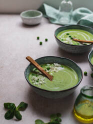 From above of delicious pea cream soup in bowls served on table - ADSF24605