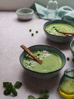 Von oben köstliche Erbsencremesuppe in Schalen auf dem Tisch serviert - ADSF24605