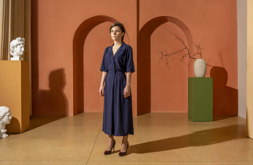 Young woman standing in front of orange wall - VPIF04037