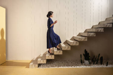 Junge Frau bewegt sich auf einer Treppe nach oben - VPIF04048