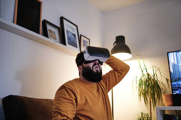 Matured man using virtual reality simulator at home - ASGF00318
