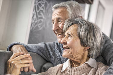 Ältere Frau hält die Hand ihres Mannes im Wohnzimmer - AUF00627