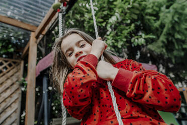 Girl hanging on swing in garden - OGF01033