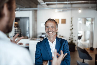 Colleague having discussion with businessman at office - GUSF05761