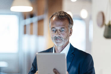 Businessman using digital tablet in office - GUSF05799