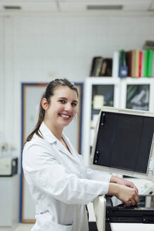 Smiling young female medical expert working in laboratory - PGF00590
