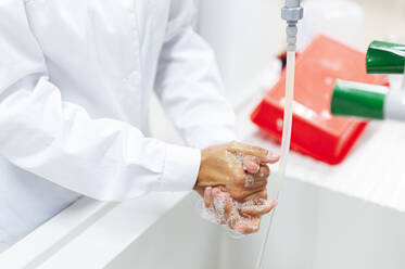 Älterer medizinischer Experte beim Händewaschen im Labor - PGF00592
