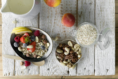 Gesundes Frühstück: Müsli, Obst, Milch auf rustikalem Holztablett - ASF06764