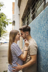 Romantischer Freund und Freundin auf dem Fußweg an der Mauer - GRCF00708