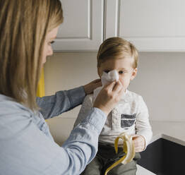 Mutter putzt die Nase des Sohnes zu Hause - HWHF00023