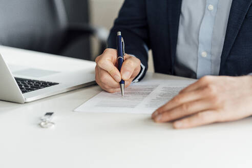 Businessman signing contract on desk in office - VPIF04073