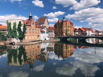 Deutschland, Hessen, Eschwege, Stadthäuser spiegeln sich auf der glänzenden Oberfläche der Werra - PUF01967