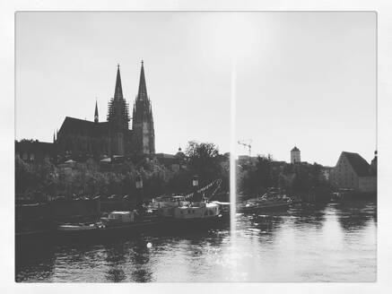 Deutschland, Bayern, Regensburg, Sonne scheint über Boote, die am Regensburger Dom vorbeifahren - PUF01975