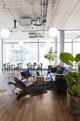 Empty chairs and sofa arranged in modern office cafeteria - FKF04159