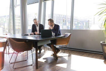 Mature businessmen working at desk in office - FKF04231