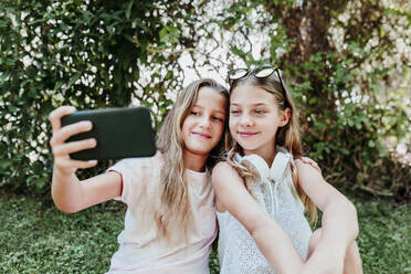 Freunde nehmen Selfie beim Genießen im Garten - EBBF03760