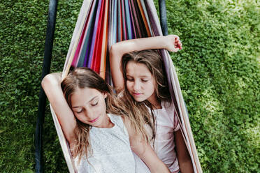 Friends resting in hammock at garden - EBBF03764