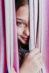 Girl peeking through hammock - EBBF03766