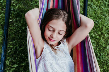 Girl with eyes closed relaxing in hammock - EBBF03767