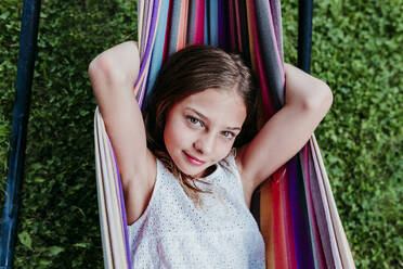 Brown eyed girl resting in hammock at garden - EBBF03768