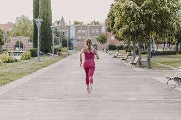 Aktive Sportlerin beim Laufen im Park - EBBF03800