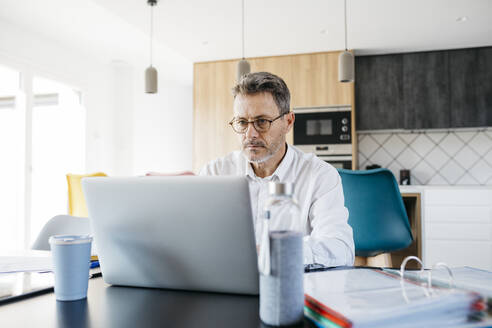 Seriöser Geschäftsmann arbeitet am Laptop im Home Office - JRFF05132