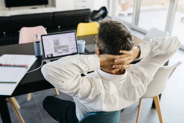 Entspannte männliche Design-Profi mit Händen hinter dem Kopf sitzen vor dem Laptop im Büro zu Hause - JRFF05148