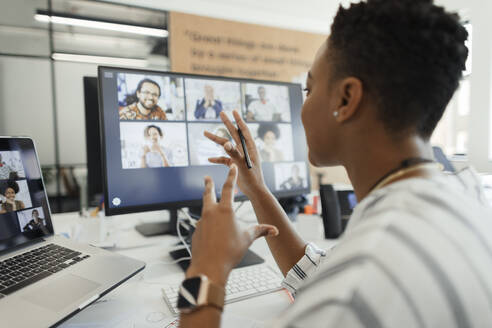 Businesswoman vide chatting with coworkers at computer in office - CAIF30388